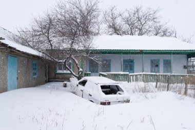 Karlı Köyü yard ortasında terk edilmiş bir araba ile bir kar fırtınası sırasında