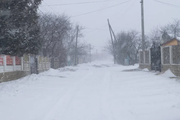 A snowy village street during a snow storm. — Stock Photo, Image