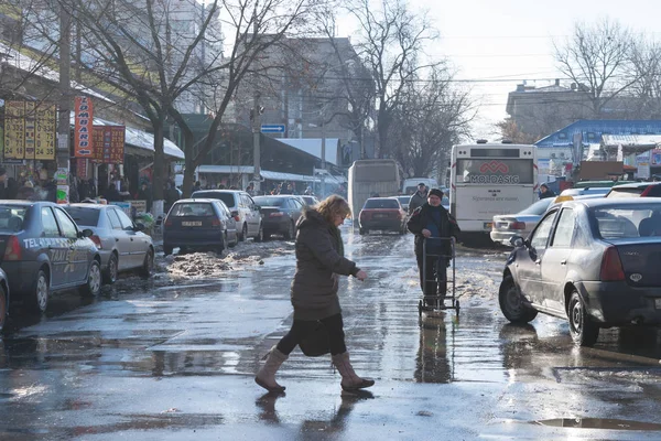 КИСИНАУ, МОЛДОВА - 14 ЯНВАРЯ, 2017: Женщина, переходящая улицу в оживленном районе Центрального рынка в Кишиневе, Молдова — стоковое фото