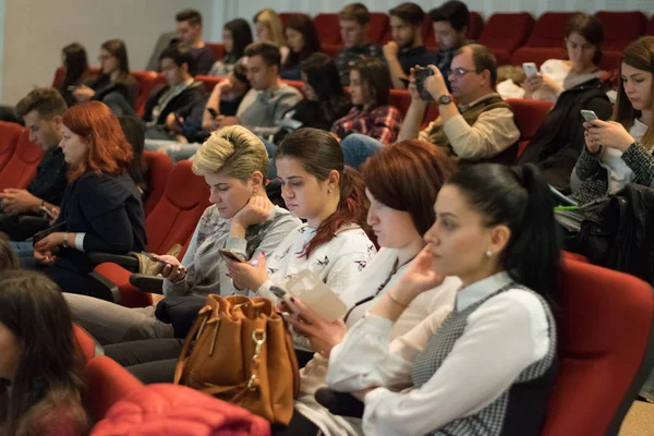 SIBIU, ROMANIA - 23 OCTOBER, 2017: Students listening while looking at their phones at a conference — Stock Photo, Image