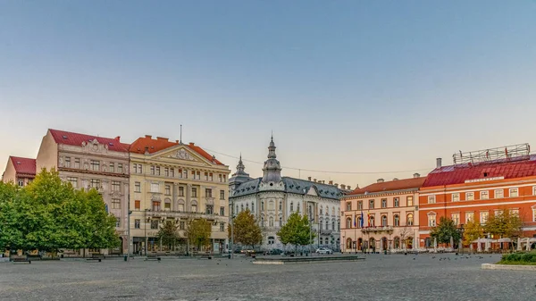 Cluj-Napoca centro da cidade. Vista da Praça Unirii para o Palácio Josika, Palácio Rhedey e New York Hotel ao nascer do sol em um belo dia de céu limpo . — Fotografia de Stock