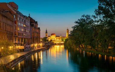 Oradea, Romanya - 28 Nisan, 2018: Crisul nehir ve gün batımında arka planda Oradea City Hall