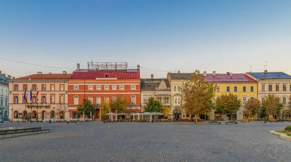 Cluj-Napoca centrum. Visa från torget Unirii till Josika Palace, Rhedey Palace och Wass Palace vid soluppgången på en härlig, klar himmel dag. — Stockfoto