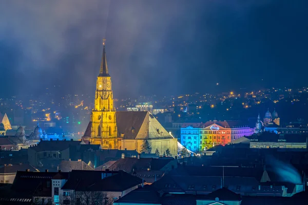 Kaloşvar eski şehir Fransisken Kilisesi ve St Michael's Kilisesi ile Cetatuia Parkı'ndan geceleri Kaloşvar, Romanya'da görüntülendi.