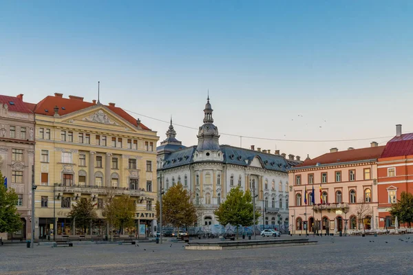 CLUJ-NAPOCA, ROMÉNIA - 13 de outubro de 2018: Centro da cidade de Cluj-Napoca. Vista da Praça Unirii para o Palácio Rhedey e o Hotel New York ao nascer do sol em um belo dia de céu limpo — Fotografia de Stock