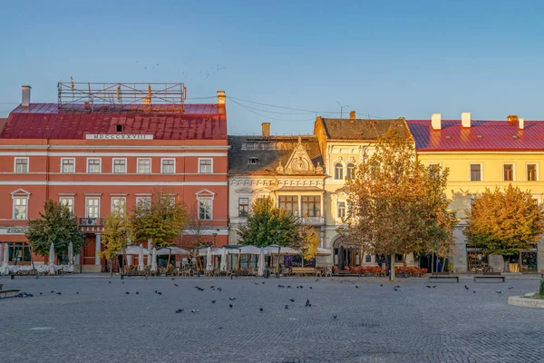 CLUJ-NAPOCA, ROMANIA - 13 de octubre de 2018: Centro de Cluj-Napoca. Vista desde la Plaza Unirii hasta el Palacio Josika y el Palacio Wass al amanecer en un hermoso y claro día de cielo . — Foto de Stock