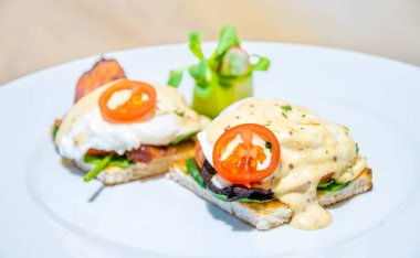 Pastırma, hardal sos ve salata yumurtalı ekmek üzerinde güzel benedict yumurtası