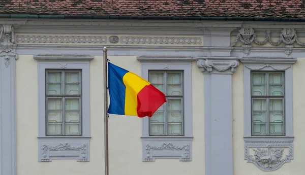 Bandeira romena em direção a um antigo edifício em Sibiu, Romênia — Fotografia de Stock