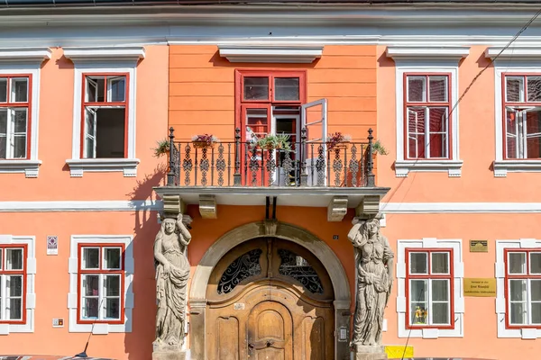 Sibiu, Romania - House with Caryatides - Beautiful house with identical statues and a balcony on a sunny summer day in Sibiu, Romania — Stock Photo, Image