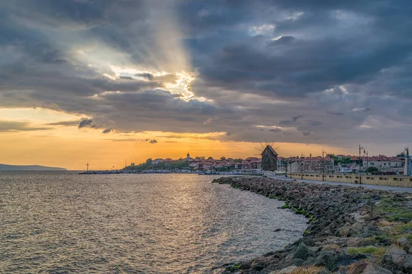 Deniz yel değirmeni, Bulgar Karadeniz sahili 'nde güneşin doğuşunda Nessebar antik kentine giden sokakta. Nesebar veya Nesebr bir UNESCO Dünya Mirası alanı. Nessebar 'a giden Isthmus — Stok fotoğraf