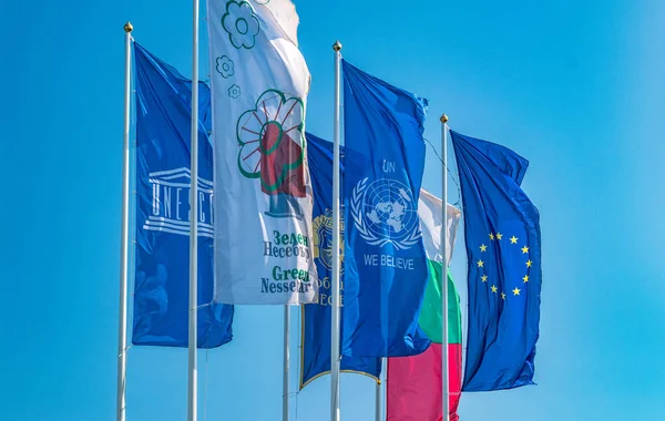 Bandeiras da União Europeia, Nações Unidas, Unesco, Bulgária e Nessebar acenando ao vento. Bandeiras da UE, ONU, Unesco, Bulgária e Nessebar contra um céu azul — Fotografia de Stock