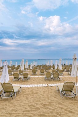 Bulgaristan'ın Karadeniz kıyısında Sunny Beach güzel bir plajda sandalye ve şemsiye.