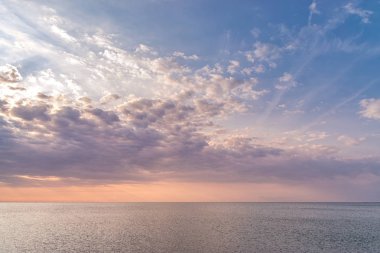 Macenta bulutları ve denizde güzel renkler ile güzel bir gün batımı. Denizde güzel gündoğumu bulutları.