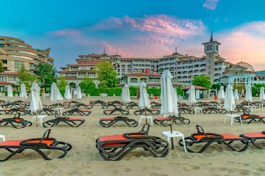 Sunny Beach, Bulgaristan - 4 Eylül 2018: Bulgaristan'ın Karadeniz kıyısındaki önemli bir sahil beldesi olan Sunny Beach'te gün doğumunda şemsiye ler ve sandalye salonları