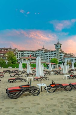 Sunny Beach, Bulgaristan - 4 Eylül 2018: Bulgaristan'ın Karadeniz kıyısındaki önemli bir sahil beldesi olan Sunny Beach'te gün doğumunda şemsiye ler ve sandalye salonları