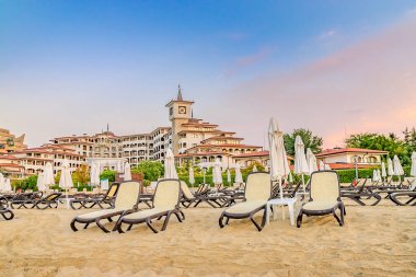 Sunny Beach, Bulgaristan - 4 Eylül 2018: Bulgaristan'ın Karadeniz kıyısındaki önemli bir sahil beldesi olan Sunny Beach'te gün doğumunda şemsiye ler ve sandalye salonları