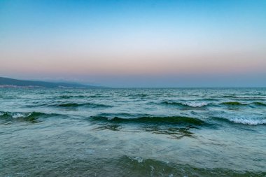 Bulgaristan'ın Karadeniz kıyısında Sunny Beach gün batımında plajda Dalgalar
