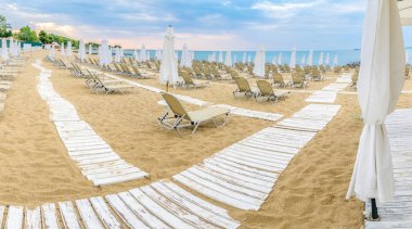 Bulgaristan'ın Karadeniz kıyısında Sunny Beach güzel bir plajda sandalye ve şemsiye.