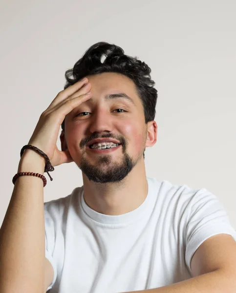 Retrato de um jovem com aparelho a sorrir. Um jovem feliz w — Fotografia de Stock