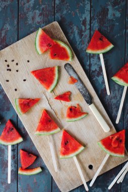 Taze organik karpuz dilimi dondurmayı rustik ahşap tahta ve taş koyu arka plan