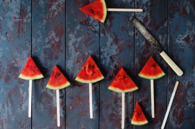 Karanlık bir rustik ahşap arka plan üzerinde taze organik karpuz dilimi popsicles