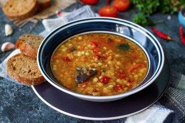 Organik kırmızı mercimek, sebze, fesleğen, sarımsak ve siyah ekmek lezzetli ev yapımı çorba 