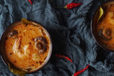 Biber biber, karides, mantar, Hindistan cevizi ve kireç karanlık bir arka plan üzerinde küçük kase lezzetli Asya çorbası tom yam