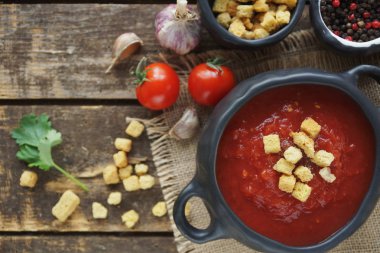 domates çorbası kraker ve karanfil vintage kumaş ve rustik ahşap arka plan, üstten görünüm.