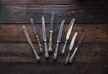 Vintage gümüş çatal bıçak takımı karanlık taş zemin üzerine. Eski mutfak eşyaları, üstten görünüm, seçici odak