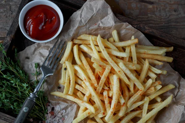kekik ve rustik ahşap masa ketçap ile kızarmış patates. Fast food cabukşalterli, sağlıksız beslenme kavramı. Seçici odak domates soslu patates kızartması