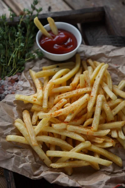 kekik ve rustik ahşap masa ketçap ile kızarmış patates. Fast food cabukşalterli, sağlıksız beslenme kavramı. Seçici odak domates soslu patates kızartması