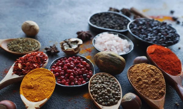Olika Indiska Kryddor Träslevar Örter Och Nötter Mörka Stenbord Färgglada — Stockfoto