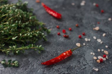 Biberiye otlar ve gri arka plan üzerinde kırmızı biber