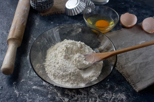 baking ingredients and cupcake forms on messy table