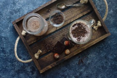 çikolatalı milkshake içinde gözlük üstten görünüm ahşap tepsi, üstten görünüm