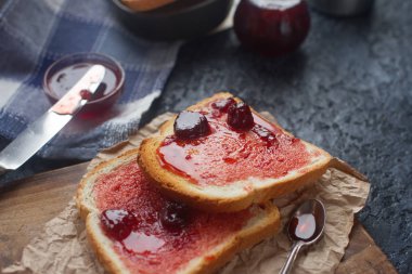Ahşap tahta üzerinde vişne reçelli taze tost