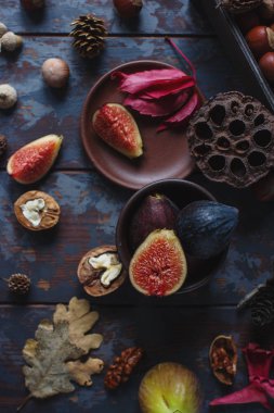 Taze organik incir, fındık ve ahşap tahta ve karanlık taş masa sonbahar yaprakları