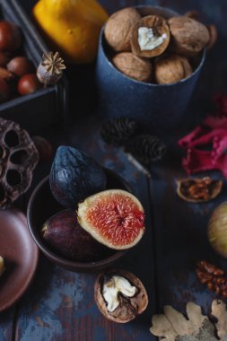 Taze organik incir, fındık ve ahşap tahta ve karanlık taş masa sonbahar yaprakları