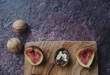 Taze organik incir, fındık ve ahşap tahta ve karanlık taş masa sonbahar yaprakları