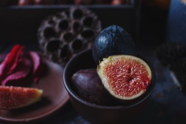 Taze organik incir, fındık ve ahşap tahta ve karanlık taş masa sonbahar yaprakları