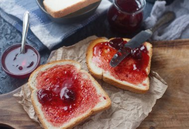 Ahşap tahta üzerinde vişne reçelli taze tost