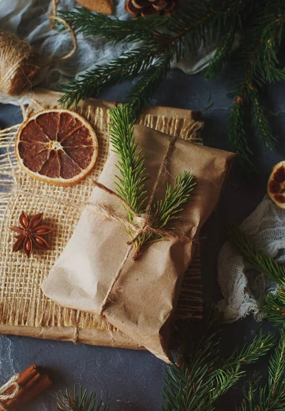 Kurutulmuş limon dilimleri ile dekore edilmiş çul çam dalları ve Noel hediyeleri sarılı