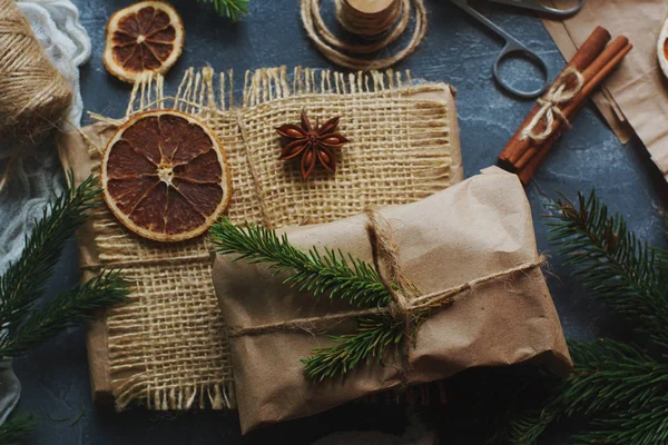 Kurutulmuş limon dilimleri ile dekore edilmiş çul çam dalları ve Noel hediyeleri sarılı