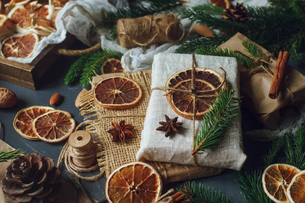 Kurutulmuş limon dilimleri ile dekore edilmiş çul çam dalları ve Noel hediyeleri sarılı