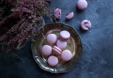 Üstten Görünüm lavanta ya da yaban mersini macaroons bahar çiçekleri ile dekore edilmiştir.