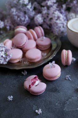 Lavanta ya da yaban mersini macaroons ve cappuccino kahve koyu taş masada yakın çekim