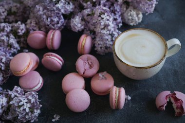 Lavanta ya da yaban mersini macaroons ve cappuccino kahve koyu taş masada yakın çekim