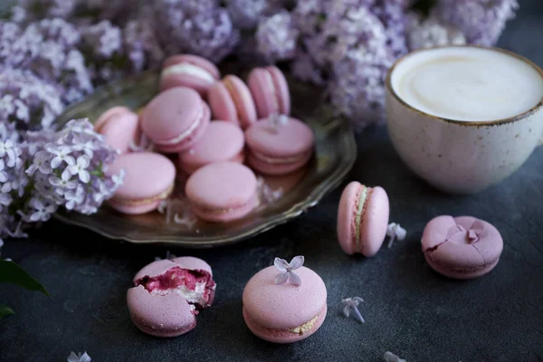 Lavanta ya da yaban mersini macaroons ve cappuccino kahve koyu taş masada yakın çekim