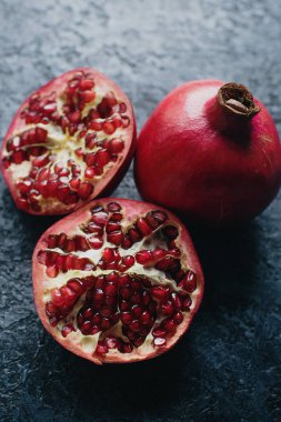 Koyu taş arka plan üzerinde taze organik sulu nar, sağlıklı yaşam tarzı kavramı