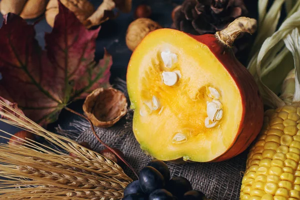 Fondo de otoño o de acción de gracias con calabaza decorativa, maíz, nueces, uvas y trigo en la mesa de piedra oscura —  Fotos de Stock